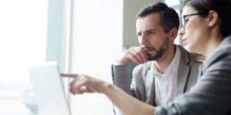 Zwei Geschäftsleute prüfen gemeinsam Informationen am Laptop