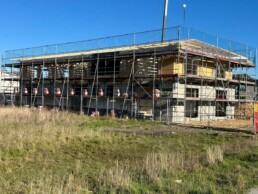 Rohbau des neuen Firmensitzes von Zenk Systempartner in Kaltenkirchen mit Gerüst und Baukran