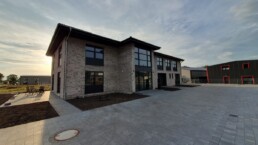 Neues Firmengebäude von Zenk Systempartner in Kaltenkirchen mit großer Fensterfront und Hoffläche