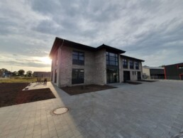 Neubau von Zenk Systempartner in Kaltenkirchen im Abendlicht mit Hof und Terrasse